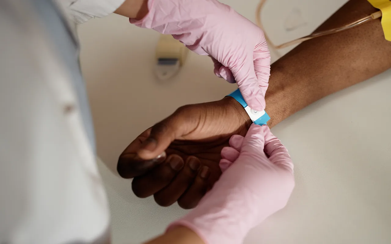 nurse placing a wrist band on a patient
